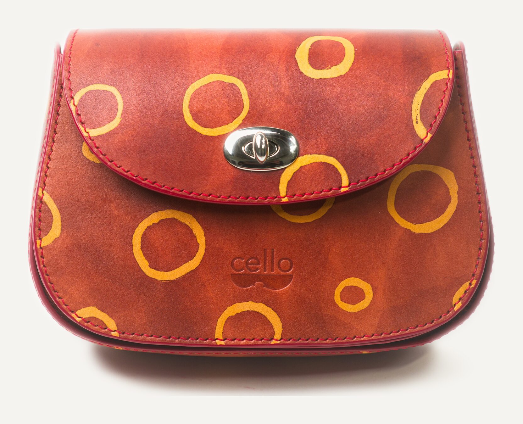 A brick-red bag scattered with loose, hand-painted golden rings